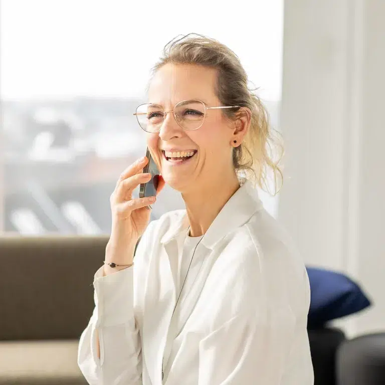 Eine lächlende Frau am Telefon