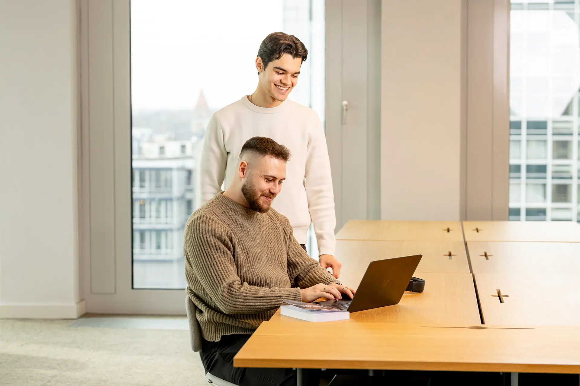 Zwei Kollegen arbeiten einem Laptop