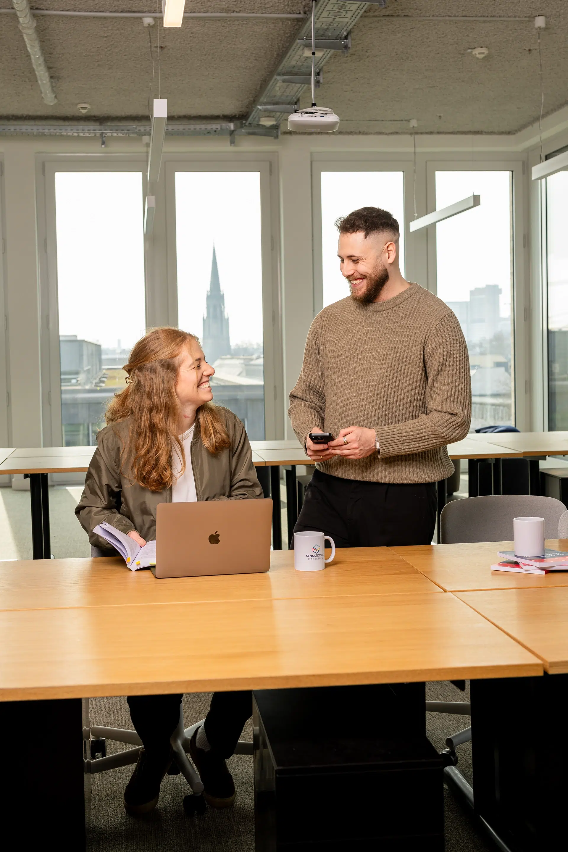 Zwei gute Kollegen, eine Mann und eine Frau lachen gemeinsam.